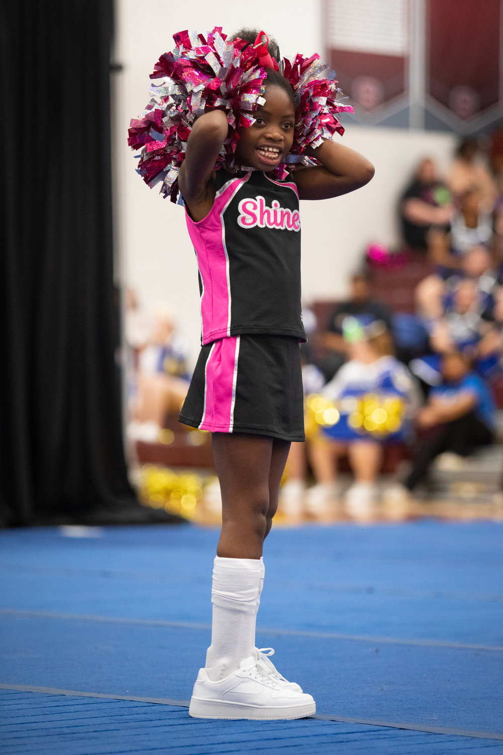 A cheerleader on the Cabarrus Shine smiles and shakes her pompoms for the crowd during her team's performance at the Special Olympics Saturday.